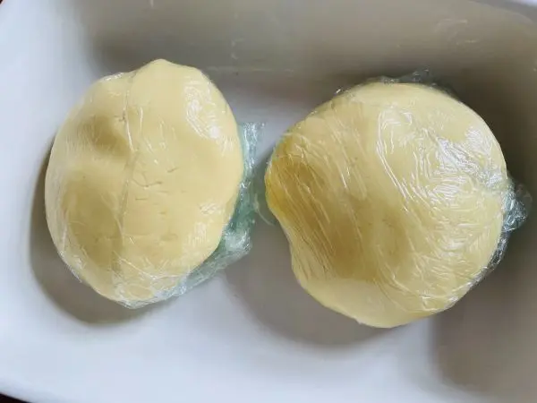 Aus dem M&uuml;rbeteig  f&uuml;r die Spiegelei-Kekse werden 2 Kugeln geformt und k&uuml;hl gestellt.