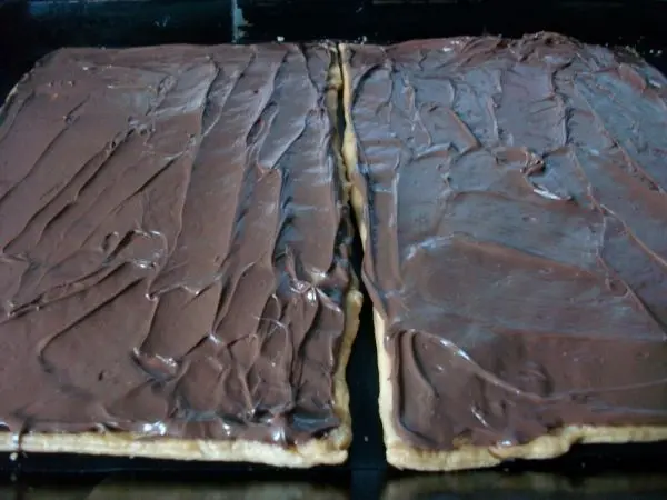 Kurz abk&uuml;hlen lassen und dann gleichm&auml;&szlig;ig die Schokoladencreme auf den M&uuml;rbteigboden aufstreichen.