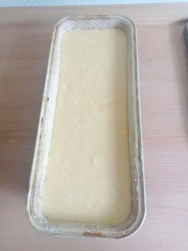 Eine Kastenform von 30 cm Länge wird eingefettet und mit Mehl ausgestreut, bevor der Teig eingefüllt wird. Eine Kastenform von 30 cm Länge wird eingefettet und mit Mehl ausgestreut, bevor der Teig eingefüllt wird.
