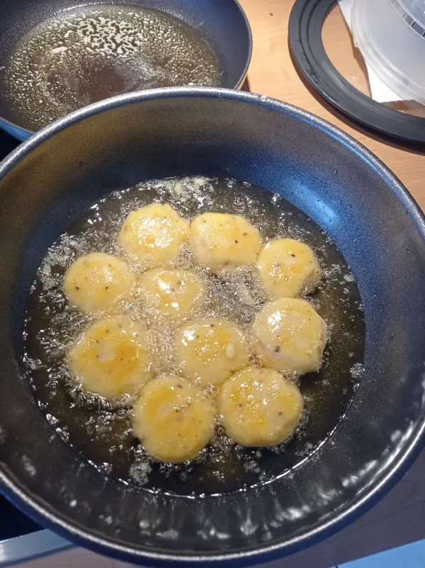 Die gut gew&uuml;rzten Kartoffelb&auml;llchen werden nun in hei&szlig;em Frittierfett rundum hellbraun ausgebacken.