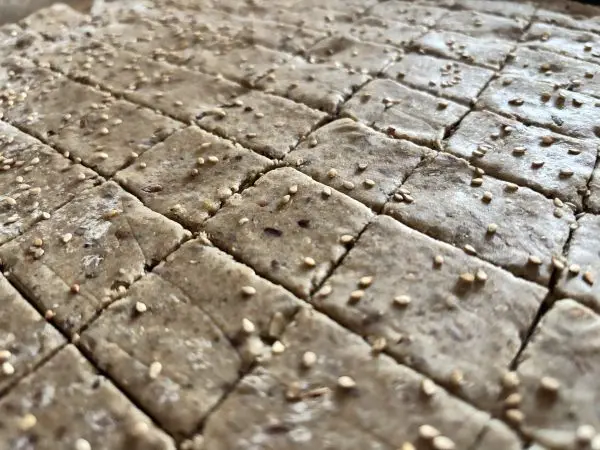 Streue gern noch ein wenig Sesam auf die Cracker, sobald du diese geschnitten hast. Meersalz eignet sich auch gut!