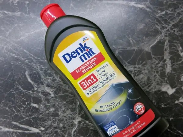Eine Flasche mit Denkmit Reinigungsmittel steht auf einer glatten, dunklen Fläche und ist für die Entfernung von Kalkflecken gedacht.