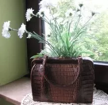 Ungewöhnliche Dekoration: alte Handtasche mit Blumenstrauß