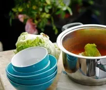 Zu viel Fett auf Suppe oder Eintopf entfernen: mit Salatblättern