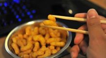 Erdnussflips-Locken am Computer essen