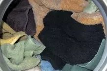 Nasse und trockene Handtücher im Trockner
