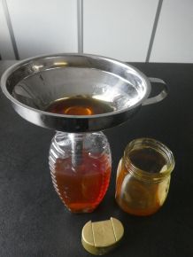 Honig aus dem Glas in vorhandene leere Flotte Biene umfüllen