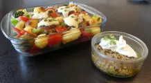 Mit Käse überbackene Pesto-Frikadellen im Gemüsebett