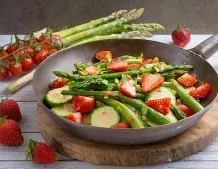 Bunte Gemüsepfanne mit grünem Spargel und Erdbeeren