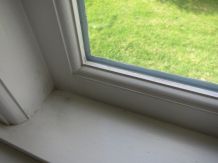 Weiße Holzfenster mit weißer Silikonfuge