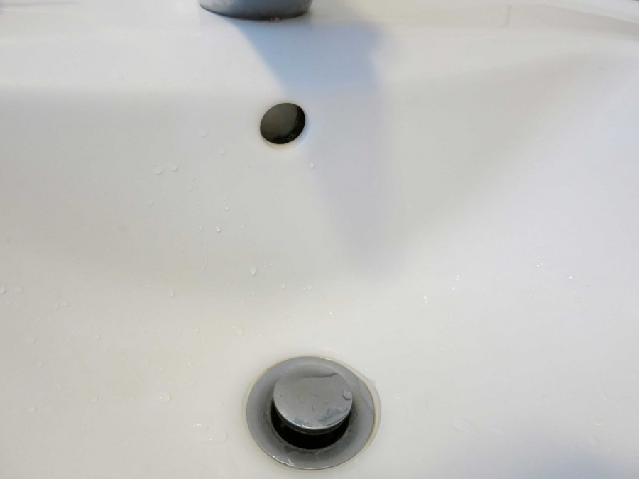 Am Überlaufloch des Waschbeckens lagert sich Kalkschmutz ab, der hartnäckig ist, weil das Becken an der Stelle nicht glasiert ist. Mit diesem Tipp gelingt es den Kalk zu entfernen. 
