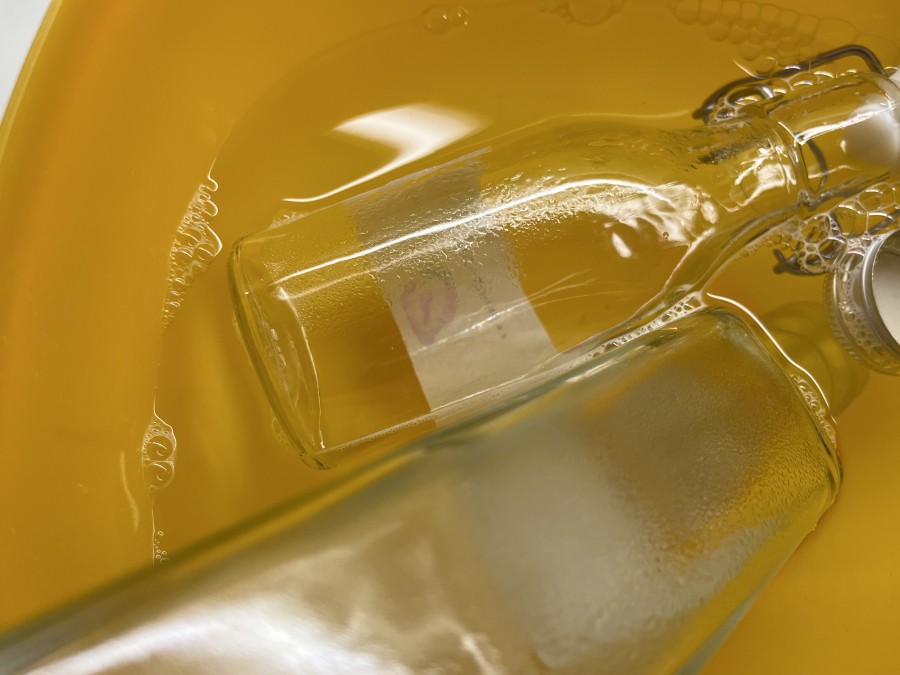 Ein Orangenreiniger Konzentrat vermischt mit Wasser dient als Bad für Flaschen.