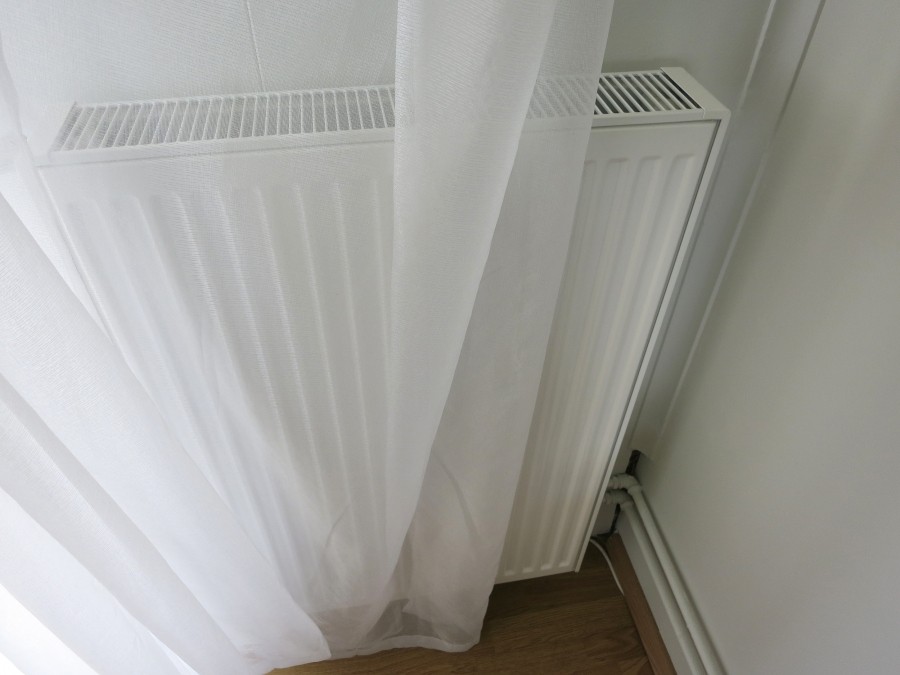 Wenn du Vorhänge vor der Heizung hängen hast, ist das ungünstig. Es entsteht zwischen Heizung und Vorhang ein "Stauraum", wo sich die Wärme sammelt. Effekt: Der Raum wird nicht richtig warm, man stellt die Heizung hoch und zahlt mehr.