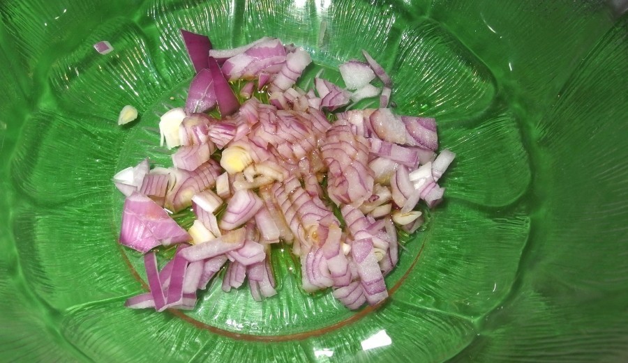 Eine in Öl zerdrückte und verrührte Zwiebel sorgt für eine würzigere Salatsoße. Erst danach werden die restlichen Zutaten der Soße untergerührt.