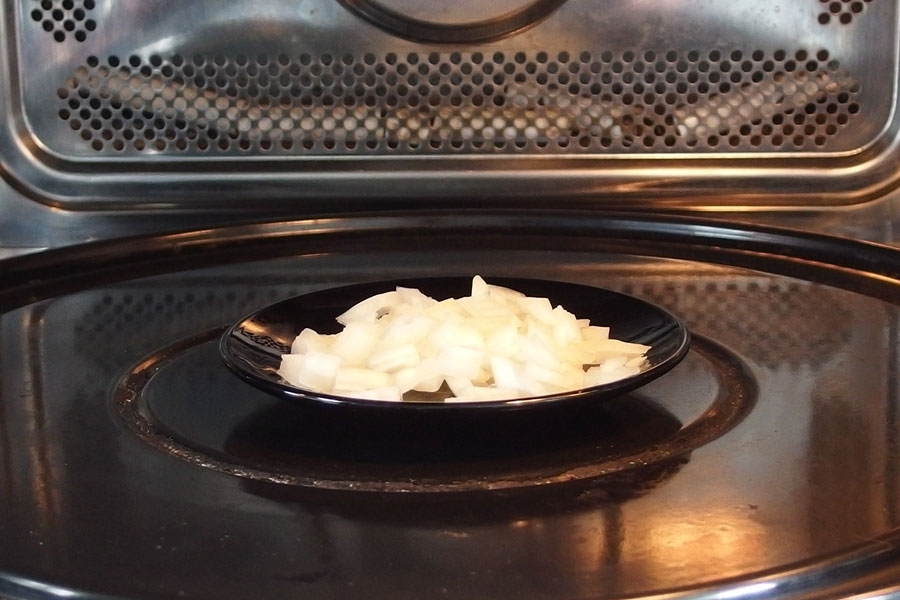 Fertig zerkleinerte Zwiebel in der Mikrowelle für Gerichte vorgaren.