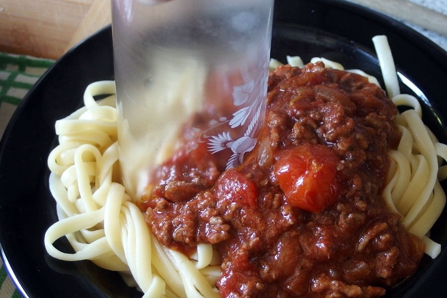 Spaghetti für Kinder, mithilfe eines Glasrandes, einfach und schnell klein schneiden.