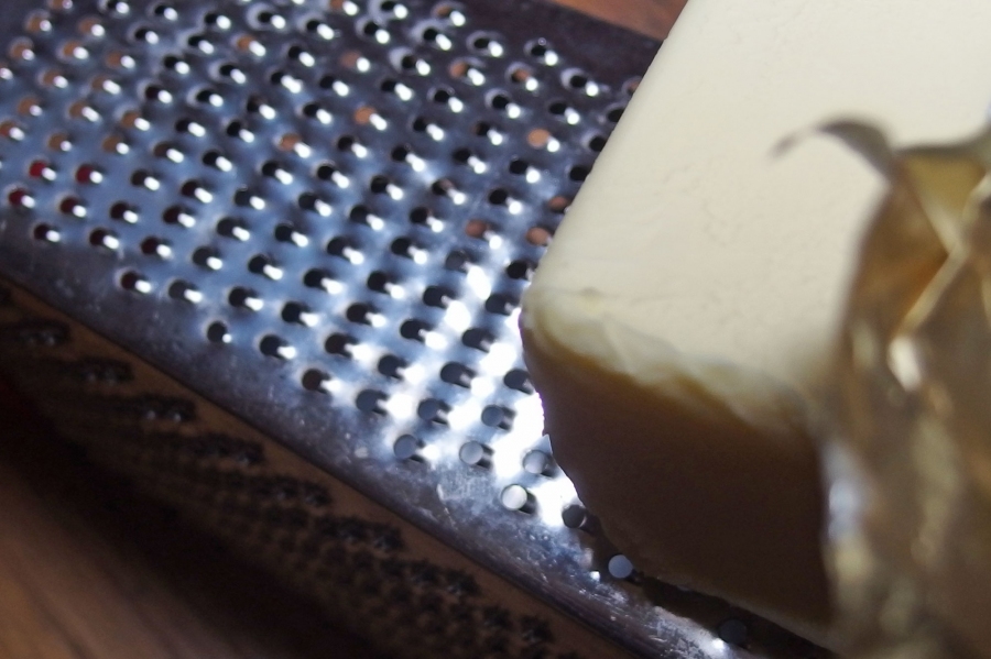 Harte Butter beim Kuchenbacken mit einer groben Reibe auf das Mehl raspeln.