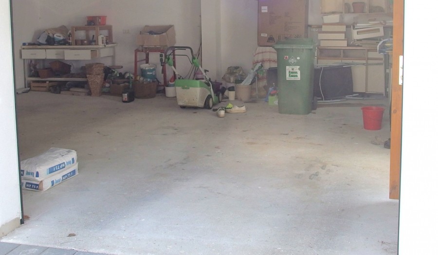 Ölfleck in der Garage mit altem Karton oder einem Pack Zeitungspapier und Wasser entfernen.