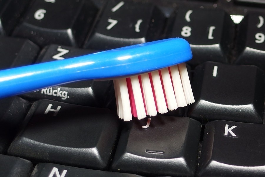 Computer Tastatur mit einer leicht feuchten Zahnbürste reinigen - man kommt damit sehr gut in die Ritzen.