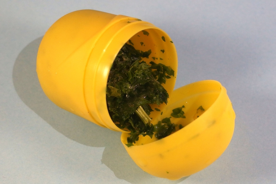 Kräuter können sehr praktisch in kleinen Portionen in einem gelben Überraschungsei-Behälter aufbewahrt werden.