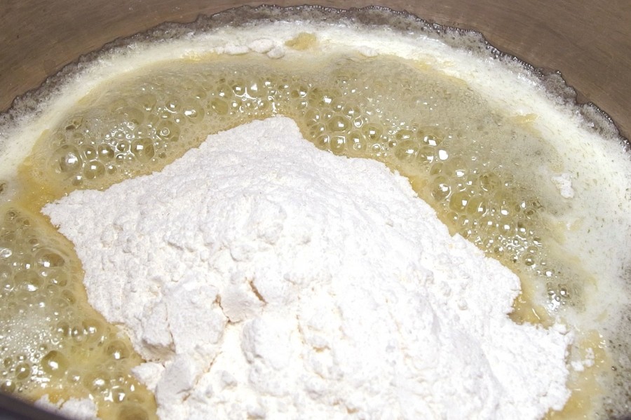 Die Butter im Topf zum Schmelzen bringen und das Mehl auf einmal hinzufügen und mit einem Schneebesen rühren, bis sich ein leichter "Pelz" am Topfboden bildet.