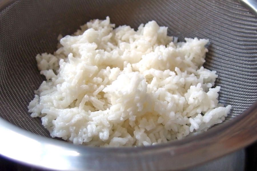 Reis in einem Haarsieb über kochendem Wasser erwärmen.