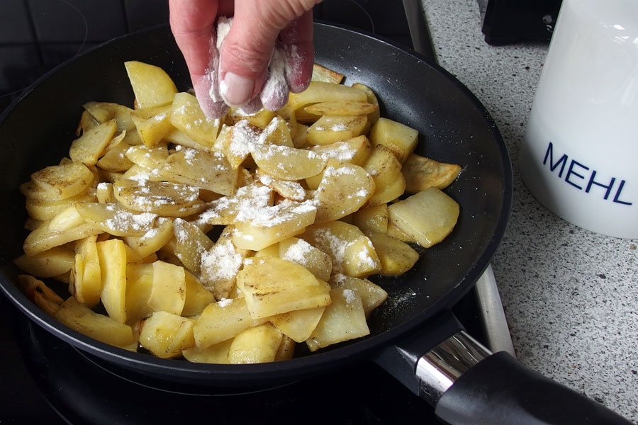 Um krosse Bratkartoffeln zu bekommen, die Kartoffeln immer wieder mit etwas Mehl bestäuben.