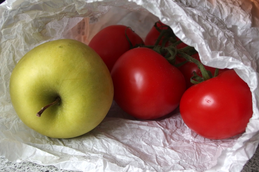 Tomaten nachreifen lassen in einer Papiertüte mit Apfel.
