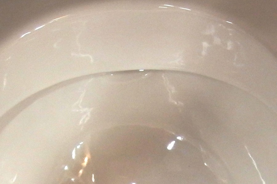 Mit Essig getränkten Tampon gegen Kalk beim Wassereinfluss im WC.