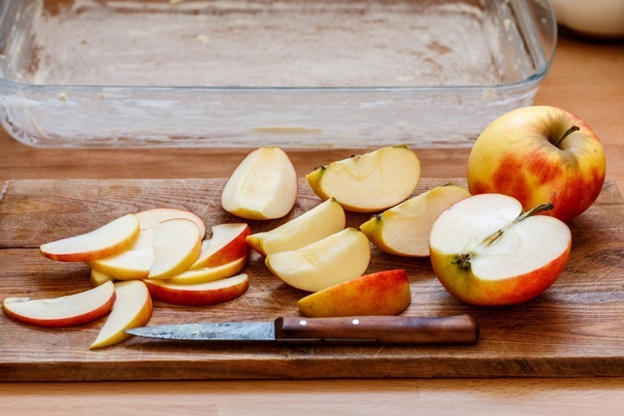Die Äpfel muss man in dünne Apfelspalten schneiden. Man kann bereits den Ofen vorheizen.