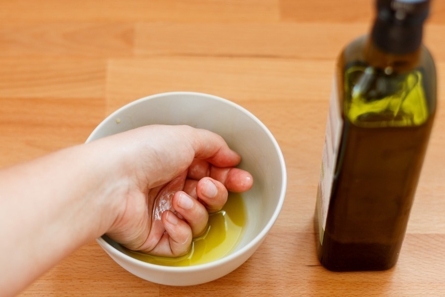 So hilfst du deinen rissigen Händen und Fingern: Olivenöl erwärmen und die Hände darin 10-15 Minuten baden. Über Nacht einziehen lassen!
