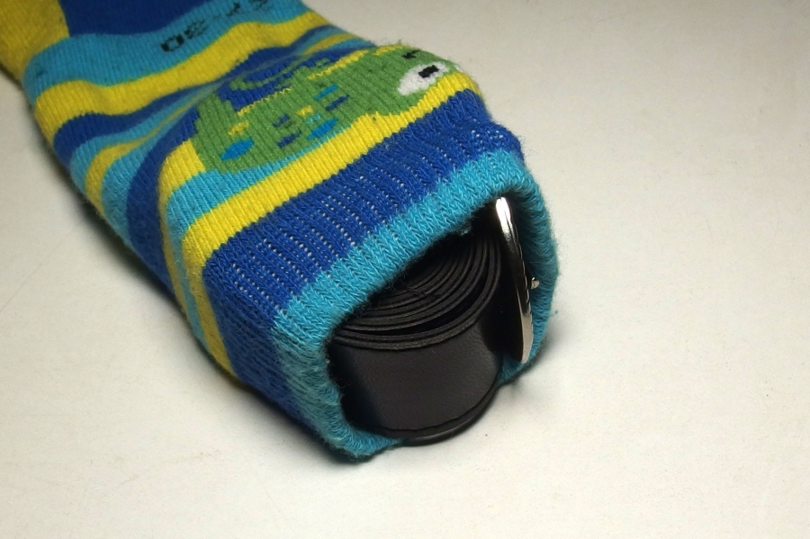 Einzelnen Socken kann man zu neuer Nutzung verhelfen. Sie dienen als Futteral für zusammengerollte Gürtel.