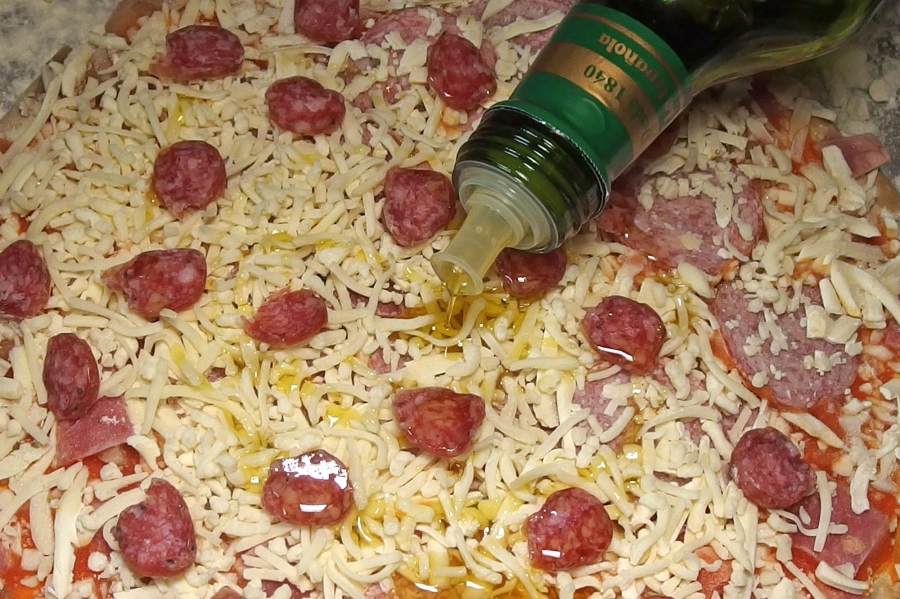 Einfach etwas Ölivenöl in kreisenden Bewegungen über die Tiefkühlpizza geben und die Pizza schmeckt wie selbst gemacht.