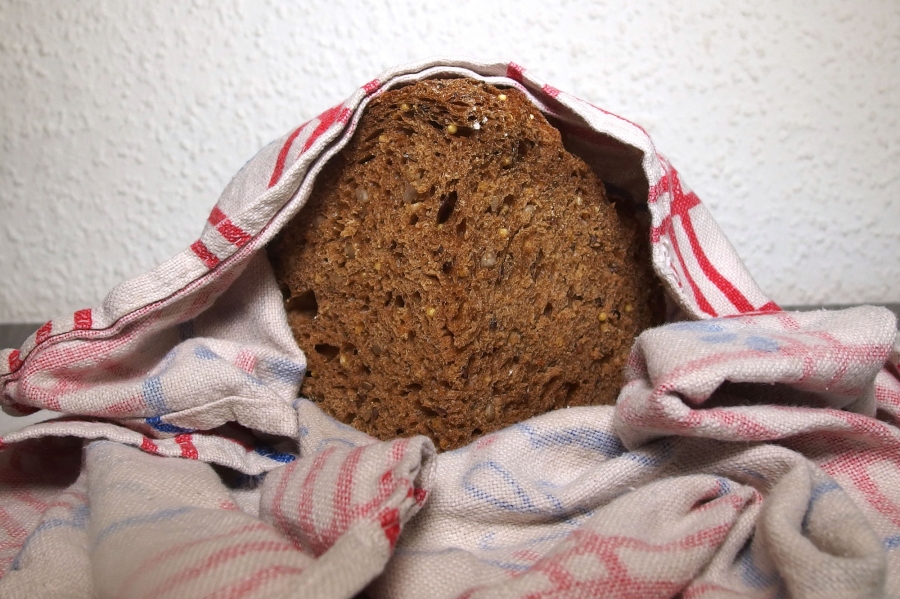 Gefrorenes Brot in einem feuchten Tuch eingewickelt in der Mikrowelle auftauen.