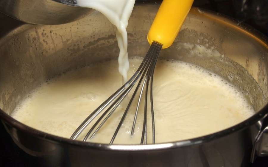 Die heiße Milch wird nun langsam unter Rühren zu der Mehlbutter gegeben. Immer nur kleine Mengen zufügen, einrühren, glatt rühren und weiter machen. 
