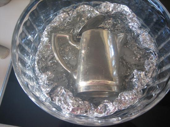 Man gibt das Silberstück in eine Schüssel, die mit Alufolie verkleidet ist. Wasser und Salz dazu und es dauert eine Weile, bis das Silber wieder glänzt.