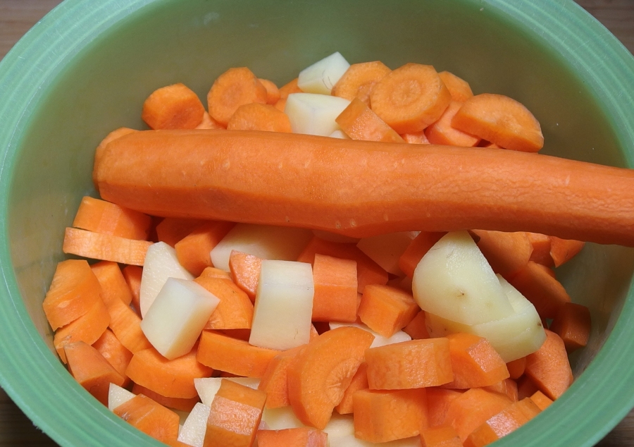 Die Möhren und auch die Kartoffeln werden geschält und in Scheiben oder Würfel geschnitten, damit sie schneller gar werden.