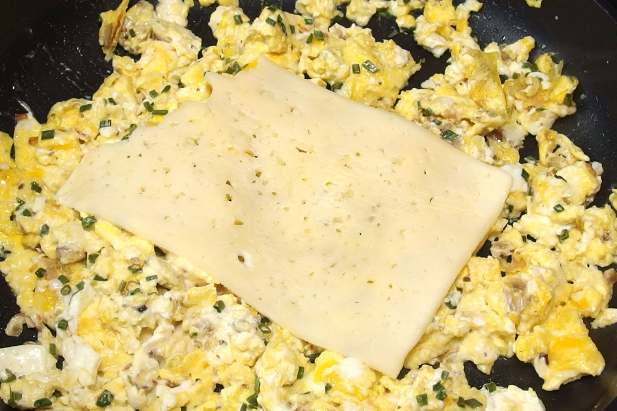 Rührei mit Käse und Schlagrahm: Auf vorgewärmten Tellern zum Frühstück servieren. Ein leckeres Sonntagsfrühstück für die ganze Familie.     
