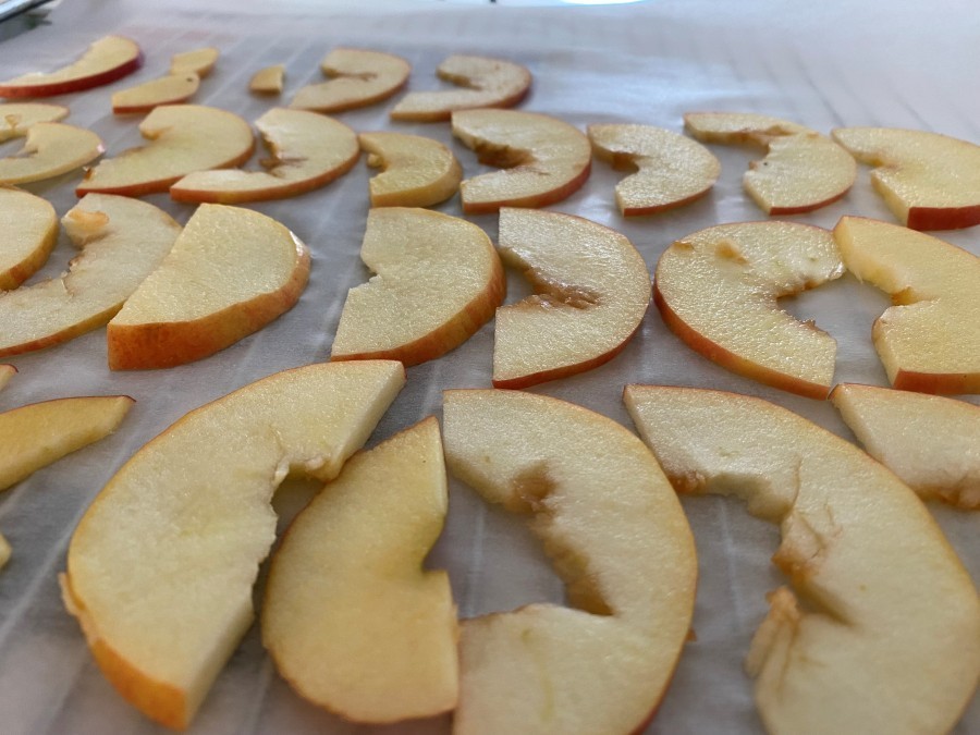 Der noch ganze, rund geschälte Apfel, wird in Scheiben geschnitten.