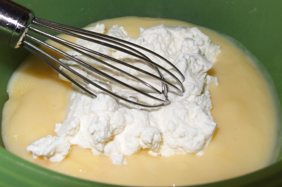 In den fertigen Pudding mit einem Schneebesen den Quark einrühren und etwas Fruchtsaft dazu, dann das Obst unterheben.