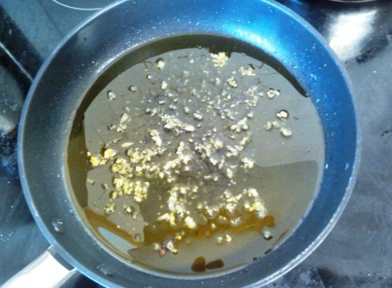 Olivenöl mit Knoblauch in einem Topf erwärmen
