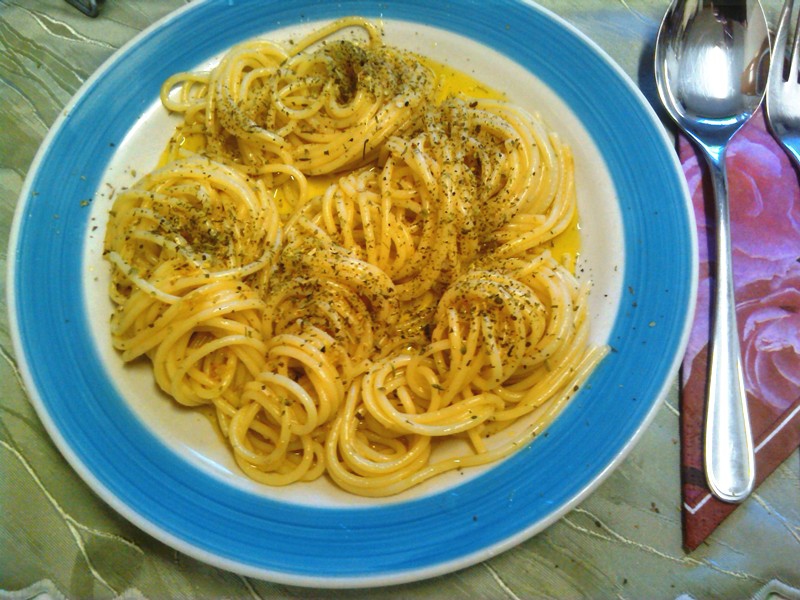 Spaghetti mit Kräutern oder Parmesan bestreuen