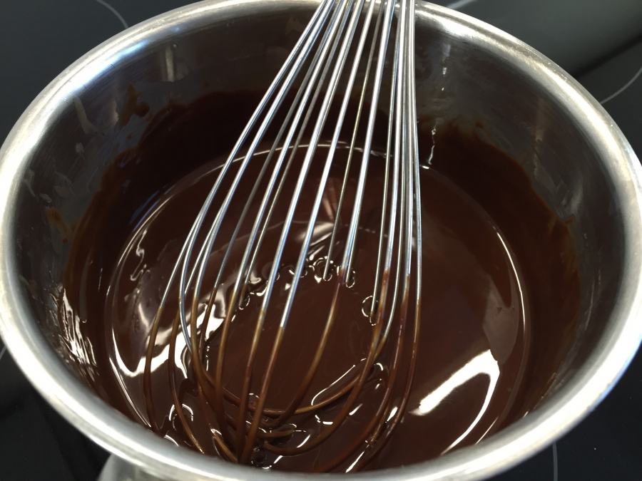 Geschmolzene Schokolade für die Schokoladen Brownies mit Schokoladenzuckerguss.