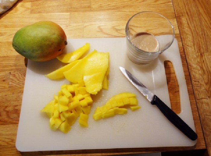 Eine reife Mango schälen, Fruchtfleisch vom Kern abschneiden, schön würfelig schneiden.