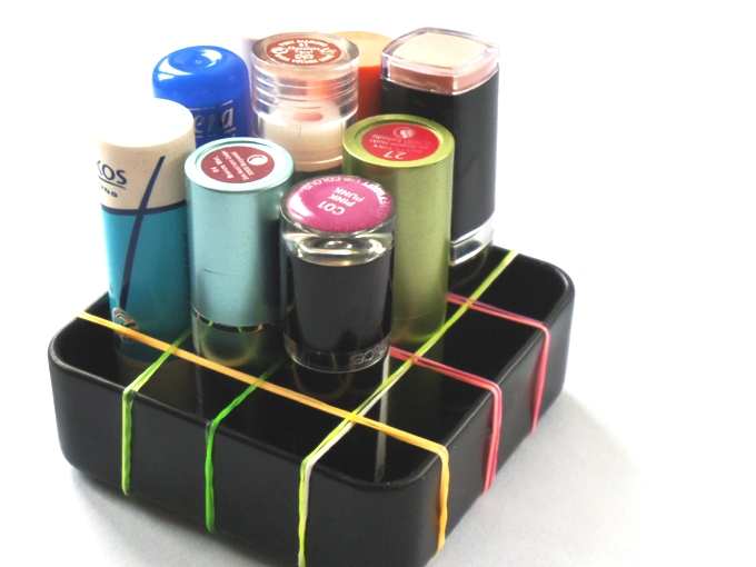 Schachtel mit Gummibändern unterteilt - tolle Aufbewahrungsbox für Lippenstifte und anderen Kram.