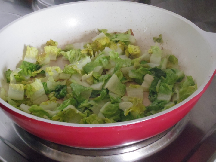 Romana-Salat längs durchschneiden und quer klein schneiden. Butter in der Pfanne schmelzen und Salat dazugeben. Bei mittlerer Temperatur dünsten. 