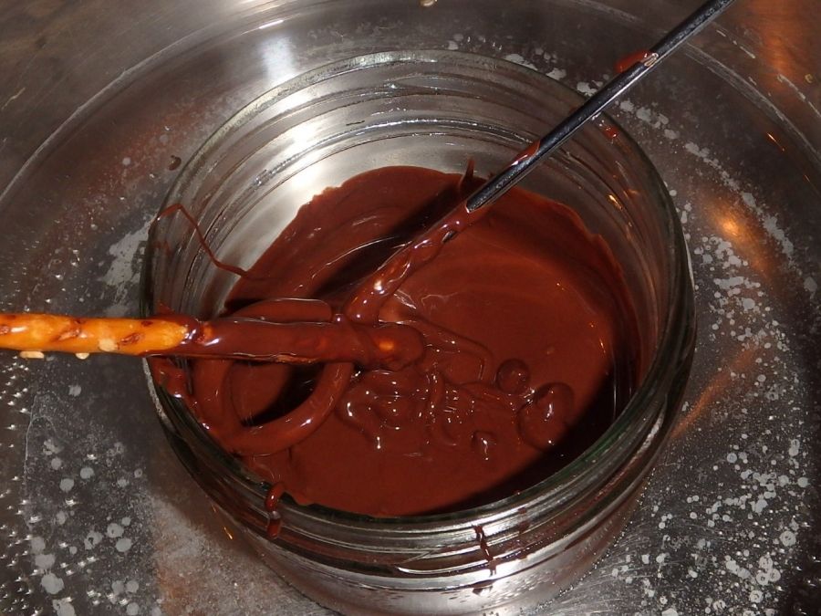 Wenn die Schokolade geschmolzen ist, die Salzstangen ca. 3 cm tief eintunken.