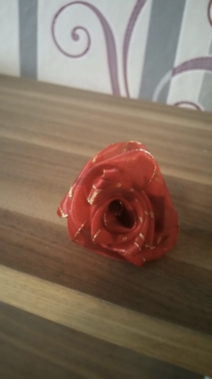 Fertig gerollte Rose aus einem Geschenkband.