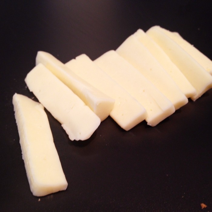 Der Käse wird in Scheiben oder Würfel geschnitten.