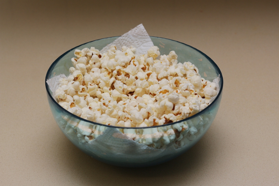 Popcorn mithilfe eines Kartoffelstampfers und einer Serviette im Topf ohne Anbrennen herstellen.